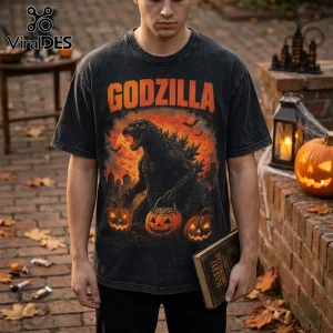 Godzilla Destroying Cities Halloween T-Shirt with an orange monster graphic, carved pumpkins, and bats on black fabric.