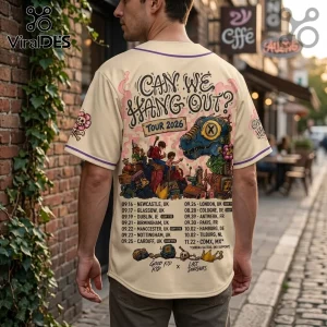 Beige button-down baseball jersey featuring cartoon dinosaur graphic, tour dates for 2026, and purple trim on sleeves.!