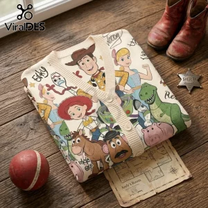 Toy Story character print beige knit cardigan featuring Woody, Buzz, Jessie, Rex, and Forky on a wood table surface.!