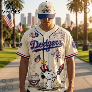 Los Angeles Dodgers cream baseball jersey featuring Snoopy holding a firework, American flags, and firework illustrations.!