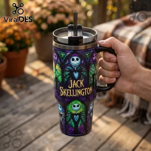 Stainless steel tumbler with Jack Skellington stained glass design and black lid held against a blurry outdoor background.!