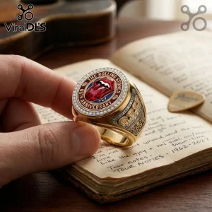 Gold Rolling Stones 65th anniversary ring with a red tongue gemstone logo, diamond bezel, and side band engravings.!