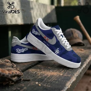 Los Angeles Dodgers x Kaws Air Force 1 sneakers in blue camo with white soles, gray swooshes, and custom logo details.