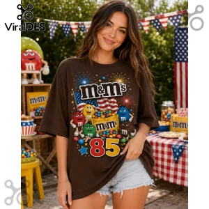 Brown cotton t-shirt featuring M&Ms characters, 85th anniversary graphics, fireworks, and an American flag print.!