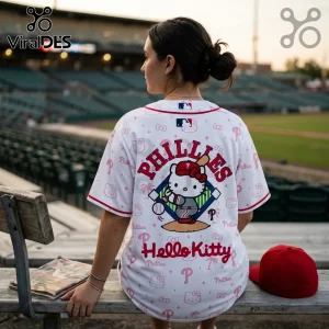 Woman wearing white Philadelphia Phillies baseball jersey with Hello Kitty graphic sitting on stadium bench.!