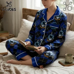 Woman wearing blue and black checkered Ravenclaw pajama set with house crests, sitting on bed reading a book.!