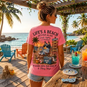 Pink t-shirt featuring Bluey cartoon character, beach scene, and text Life’s a Beach worn by a woman at a tropical resort.!