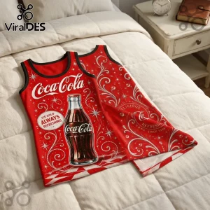 Red Coca-Cola branded tank top with white swirling floral patterns and a glass bottle graphic on a white quilted bedspread.!
