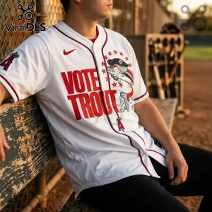 White baseball jersey with red text Vote Trout, an illustrated trout in a captain hat, and Los Angeles Angels team logos.!