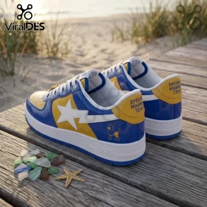 Blue and yellow patent leather sneakers with white star logos, poodle embroidery, and Greek text on wooden boardwalk.!