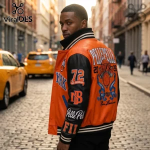 Man wearing orange and black leather Pelle Pelle New York Knicks varsity jacket on a city street.!