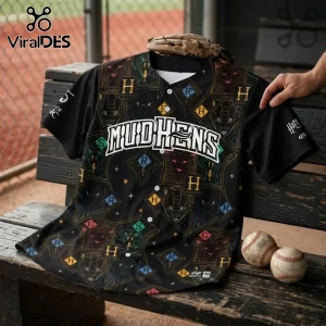 Toledo Mud Hens x Harry Potter black baseball jersey with house crests, lettering, and magical motifs on a wooden bench.