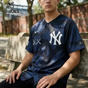 Man wearing a navy blue camouflage New York Yankees baseball jersey with white KAWS logo on the chest and sleeves.!