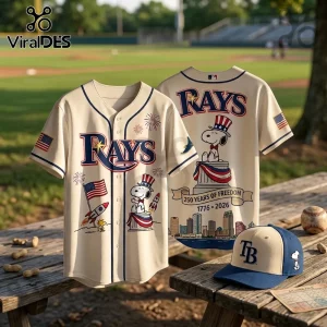 Cream baseball jersey with Tampa Bay Rays logo, Snoopy in patriotic hat, and 1776-2026 250 Years of Freedom text on bench.!
