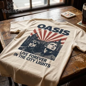 Cream colored t-shirt featuring a dark blue graphic of Liam and Noel Gallagher with red sunburst and city architecture.!
