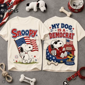 Cream colored t-shirt featuring Snoopy holding an American flag and text stating My Dog Is A Democrat on the back print.!