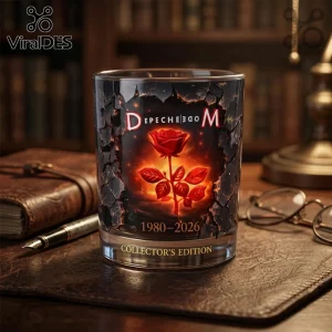 Depeche Mode whiskey glass with a red rose graphic, cracked stone texture, and 1980-2026 text on a leather desk surface.!