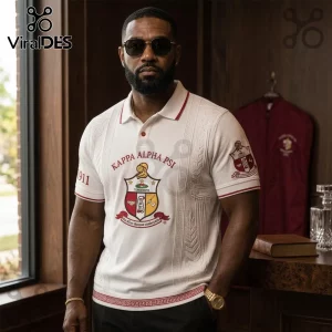 Man wearing a white Kappa Alpha Psi polo shirt with red crest embroidery, 1911 text on sleeve, and Greek key trim detail.!