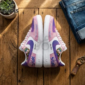 Custom pink and purple sneakers featuring cartoon graphics, white laces, and rubber soles on a wooden surface.!