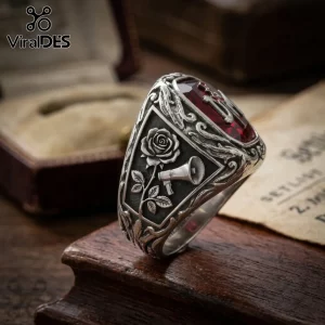 Depeche Mode Violator stainless steel ring featuring a rose, megaphone emblem, and deep red gem on a dark wood background.