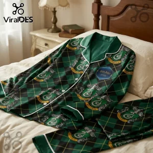 Harry Potter Slytherin pajama set with green and black argyle pattern, snake crests, and white piping on a bed.!