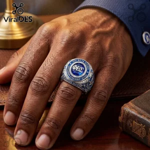 Phi Beta Sigma fraternity ring with blue stone, silver metal, and engraved text on a hand resting on a desk.!