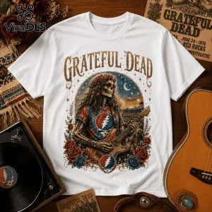 White crewneck t-shirt featuring Grateful Dead text, skeleton wearing tie-dye shirt, sunglasses, and roses playing guitar.!