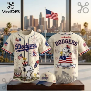 Off-white Los Angeles Dodgers baseball jersey and cap featuring Snoopy, Woodstock, fireworks, and USA flag imagery.!