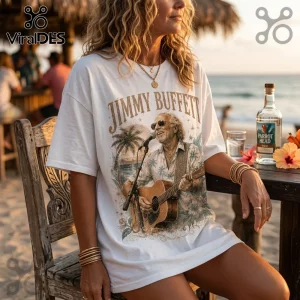 Woman wearing a vintage-style white t-shirt featuring Jimmy Buffett playing guitar on a beach with palm tree artwork.!