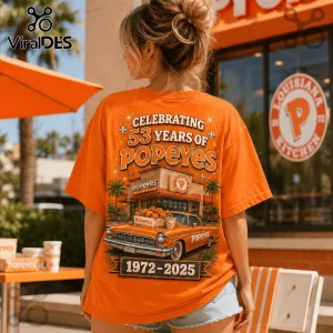 Popeyes Louisiana Kitchen 53 Years Anniversary orange t-shirt showing restaurant graphic, vintage car, and dates 1972-2025.