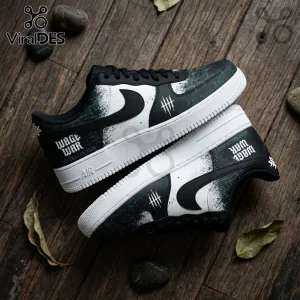 Wage War Australia 2026 Black and White Air Force 1 Sneakers featuring grunge textures on a dark wooden surface background.
