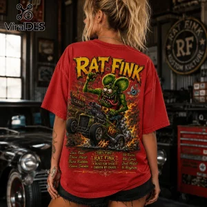 Red graphic t-shirt featuring Rat Fink character driving a hot rod, with flames and text in a garage workshop setting.!