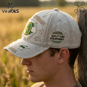 Distressed beige baseball cap with green deer emblem, anniversary text, and Quality Farm Equipment patches.!