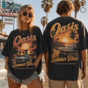 Man and woman wearing black vintage-wash t-shirts with Oasis Summer Vibes sunset beach graphics and palm tree illustrations.!