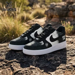 Wage War Australia 2026 Black and White Air Force 1 Sneakers featuring splatter patterns on a rocky outdoor background.