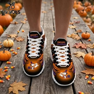Snoopy Halloween print athletic sneakers with white laces on a wood deck surrounded by pumpkins and candy corn.!