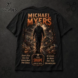 Black cotton t-shirt featuring Michael Myers graphic with orange text, pumpkins, a house, and horror quotes on a dark background.!