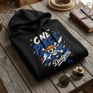 Black cotton hoodie featuring One Piece logo, Straw Hat Jolly Roger, and LA Dodgers text on a weathered wooden table.!