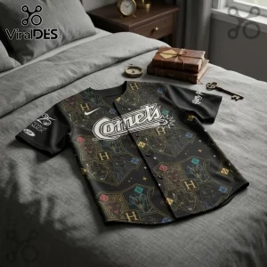Oklahoma City Comets x Harry Potter 25 Years Magic baseball jersey with house crests on a gray bedding background.