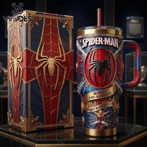 Spider-Man Marvel 64th Anniversary Stanley Tumbler with red and blue web detailing and golden emblem on a dark surface.