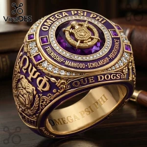 Omega Psi Phi Que Dogs gold ring featuring a central purple stone, ornate crest, side bulldog motifs, and clear crystals.