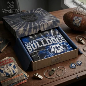 Canterbury Bankstown Bulldogs Mascot Shirt inside a tie-dye patterned gift box with rugby accessories on a wooden desk.