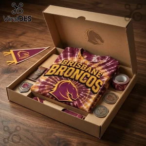 Brisbane Broncos NRL mascot tie dye shirt inside a gift box with team logo medals and a pennant on a wooden surface.