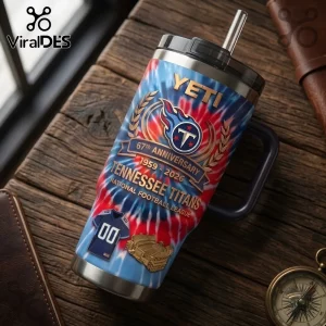 Tennessee Titans 67th Anniversary YETI Stanley Tumbler with tie-dye blue and red print on a wooden background.