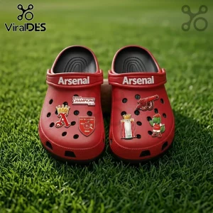 Arsenal FC Premier League Champions 25/26 Crocs With Charms in red with official team branding on a green grass background.