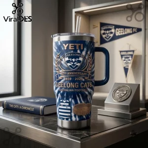 Geelong Cats 167th Anniversary Yeti Stanley Tumbler with blue tie-dye pattern, team logo, and years 1859-2026 on desk.