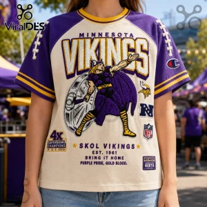 Minnesota Vikings Embroidered Mascot Champion Shirt featuring purple sleeves, cream body, and Norse warrior graphic.