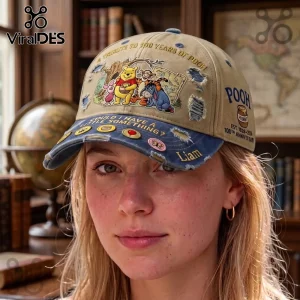 Winnie the Pooh Woodland Friends Distressed Baseball Cap in tan and denim blue with character graphics and anniversary text.