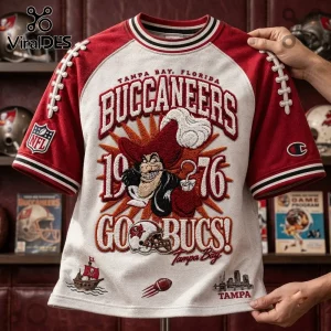 Tampa Bay Buccaneers 1976 Embossed Shirt featuring vintage pirate graphics, maroon sleeves, and embroidered text details.