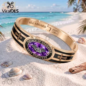Ozzy Osbourne Prince of Darkness gold tone toggle bracelet with black inlay, cross motifs, and a purple oval gem center.